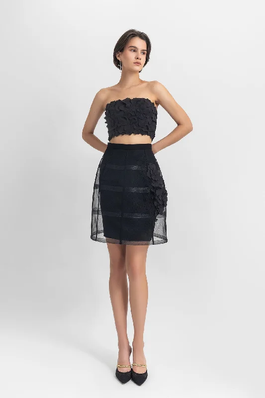 Strapless cropped-top with laser-cut details, paired with a cage-like skirt with flower details
 on the side. leather skirt durable